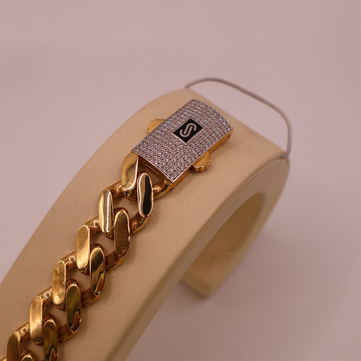 Gold curb-link bracelet, close on the pave clasp