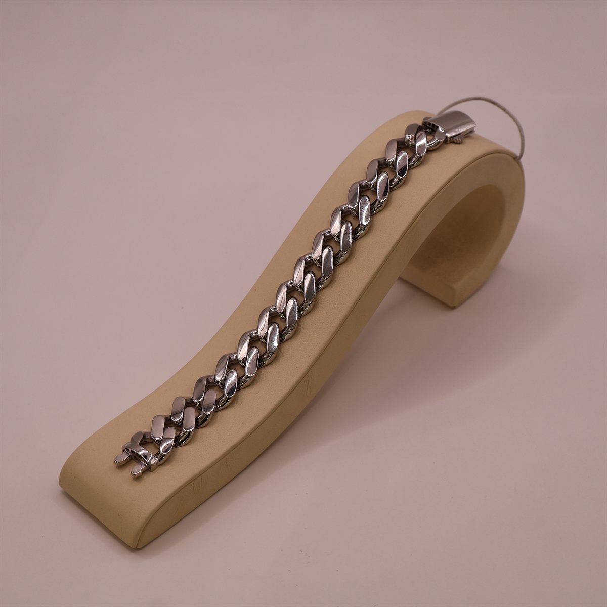 White gold curb-link bracelet laid along a display stand