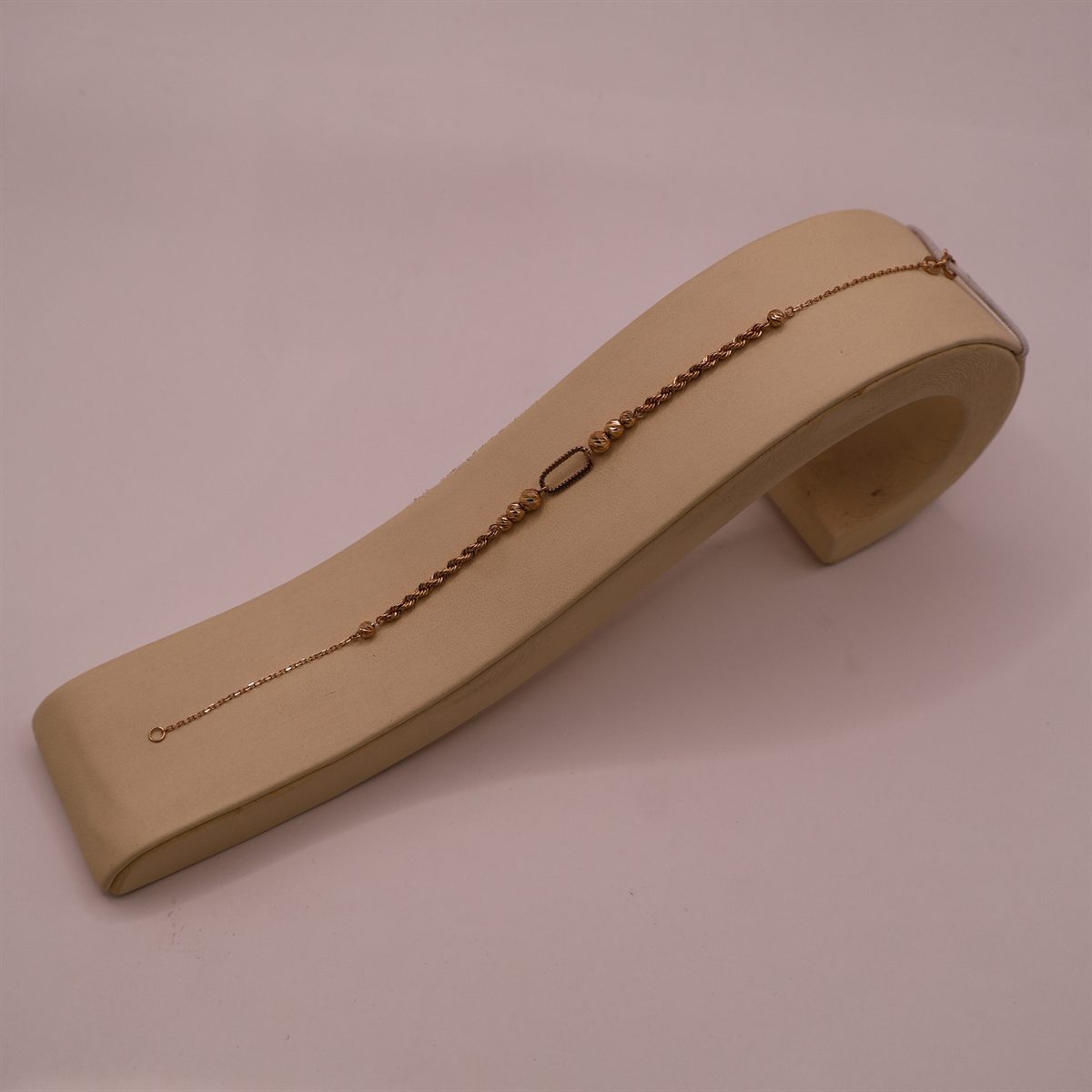 Fine gold rope chain bracelet on a display stand