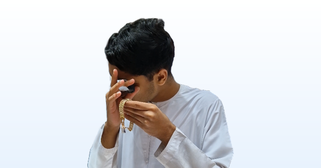 The actor inspecting a gold bracelet through a jeweller's loupe inside Al Mandoos, the shot used as the cover for this case study.